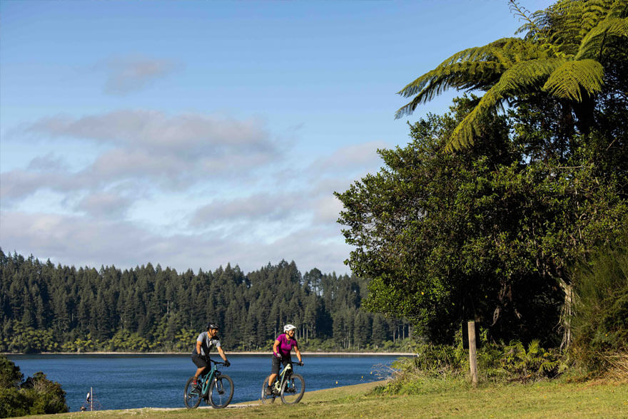 Couple cycling along Lake Tikitapu's shore.